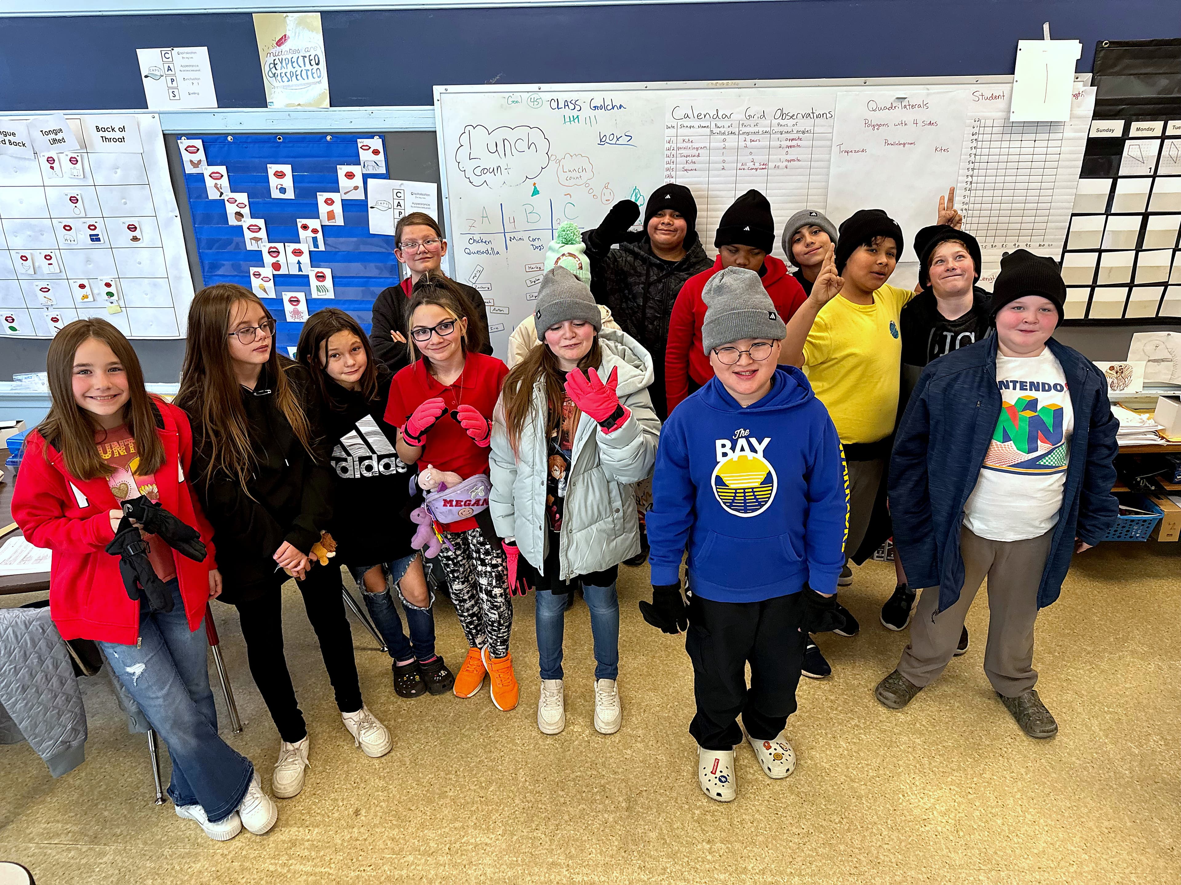 A classroom of kids wearing donated coats, hats, and gloves from a winter drive