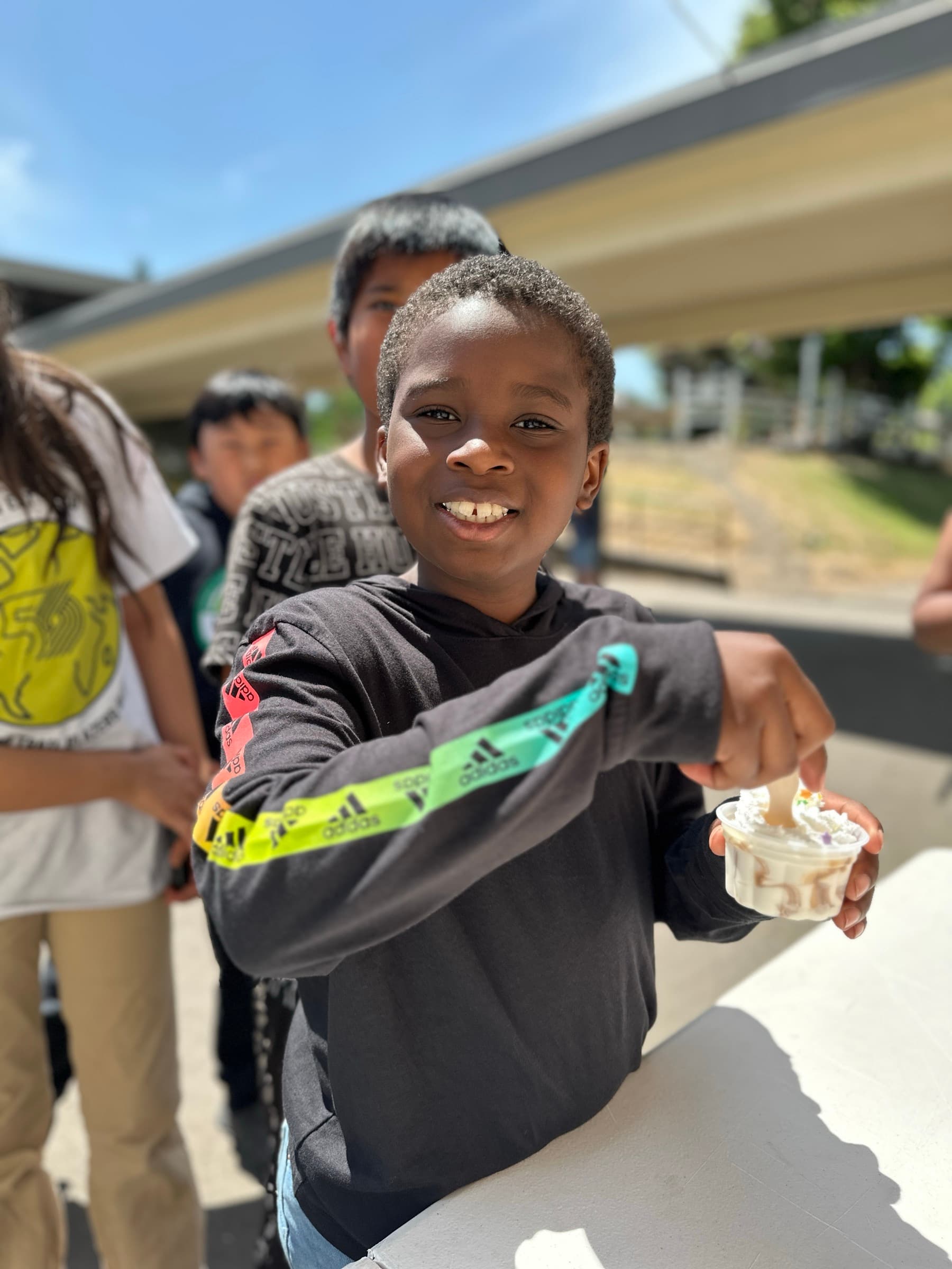 A boy smiling and holding a cup of ice cream at Oaks Park Day